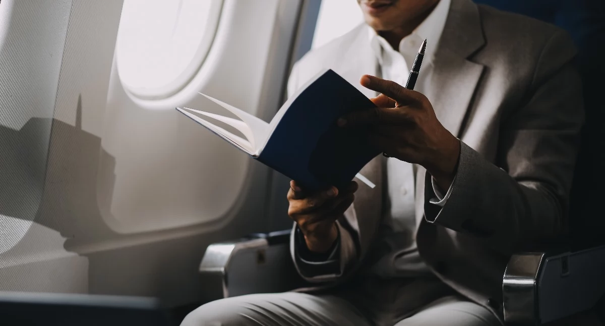 Źródło zdjęcia: https://www.vecteezy.com/photo/47375241-airplane-travel-and-portrait-of-businessman-working-on-laptop-computer-and-smartphone-while-sitting-in-airplane