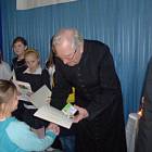 Ks. prałat Alojzy Marszall wręcza nagrodę laureatce konkursu  plastycznego Klaudii...