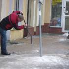 Pracownicy sklepów usuwają lód z chodników przed budynkami /fot. DWK